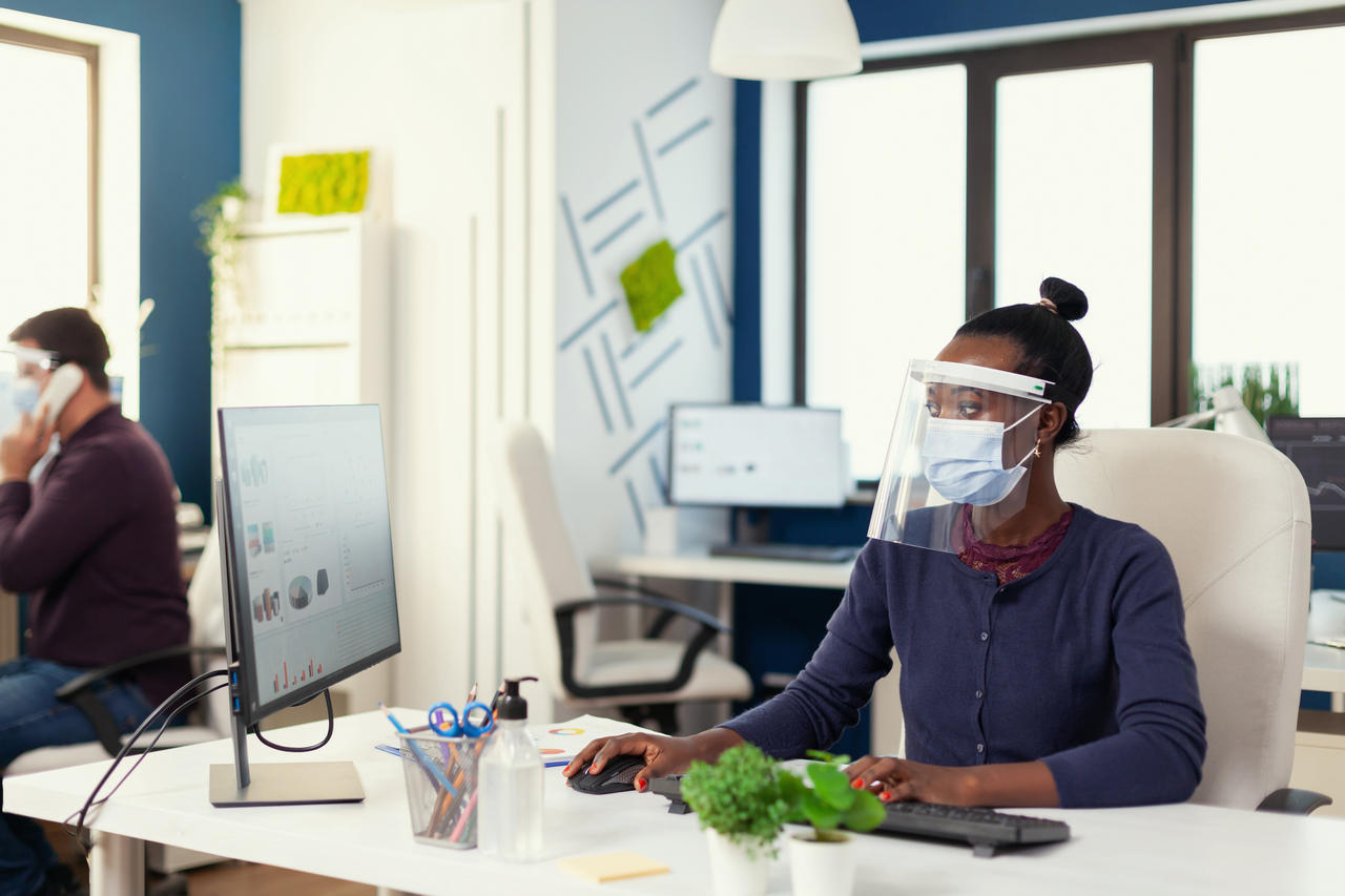 African working at workplace wearing face mask against covid19